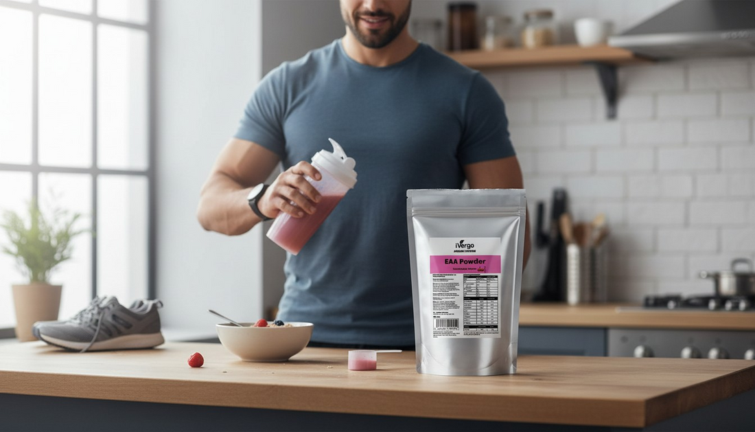 Mann in moderner Küche, der einen pinken Protein-Shaker hält, lächelt, mit iVergo EAA Powder Beutel, Beeren-Schüssel, Messlöffel und Laufschuhen auf hölzerner Theke, die einen Fitness-Lifestyle fördern.